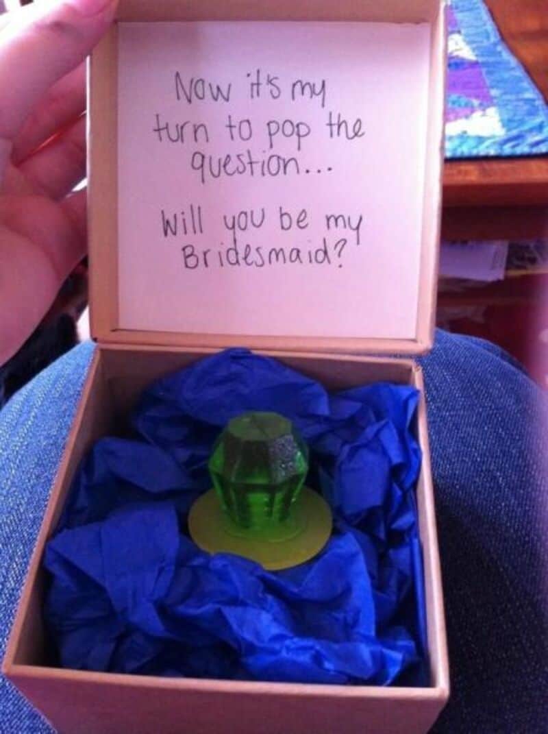 Proposal box with ring and handwritten note asking "Will you be my bridesmaid?".
