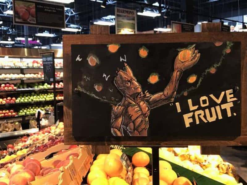 Artistic chalkboard drawing of a character reaching for fruit with "I LOVE FRUIT" text.