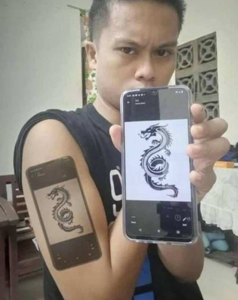 Person showing a phone with a dragon tattoo design, capturing a humorous moment.