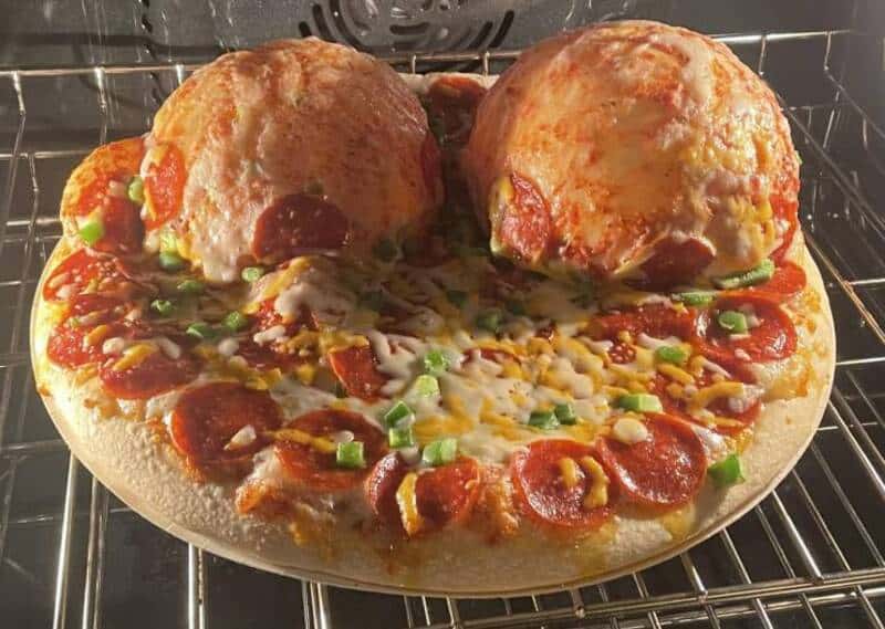 Pizza with meatballs, pepperoni, cheese, and green onions, fresh out of the oven.
