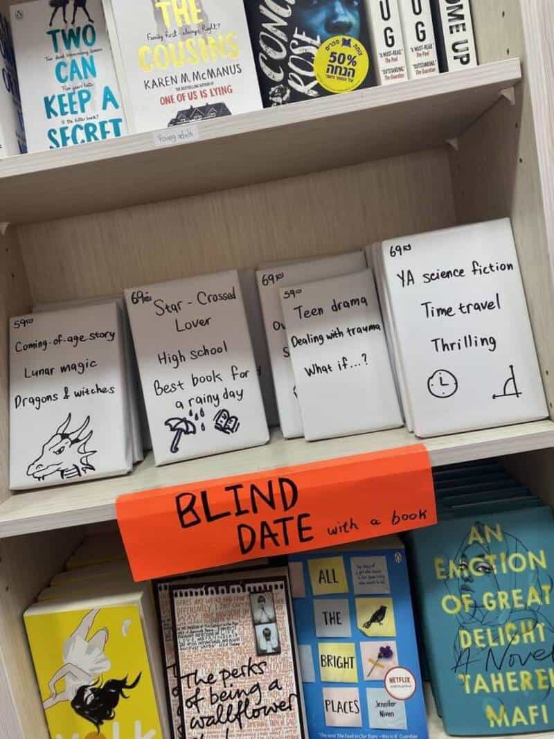 A bookshelf with books and a bright orange sign reading "BLIND DATE with a book".