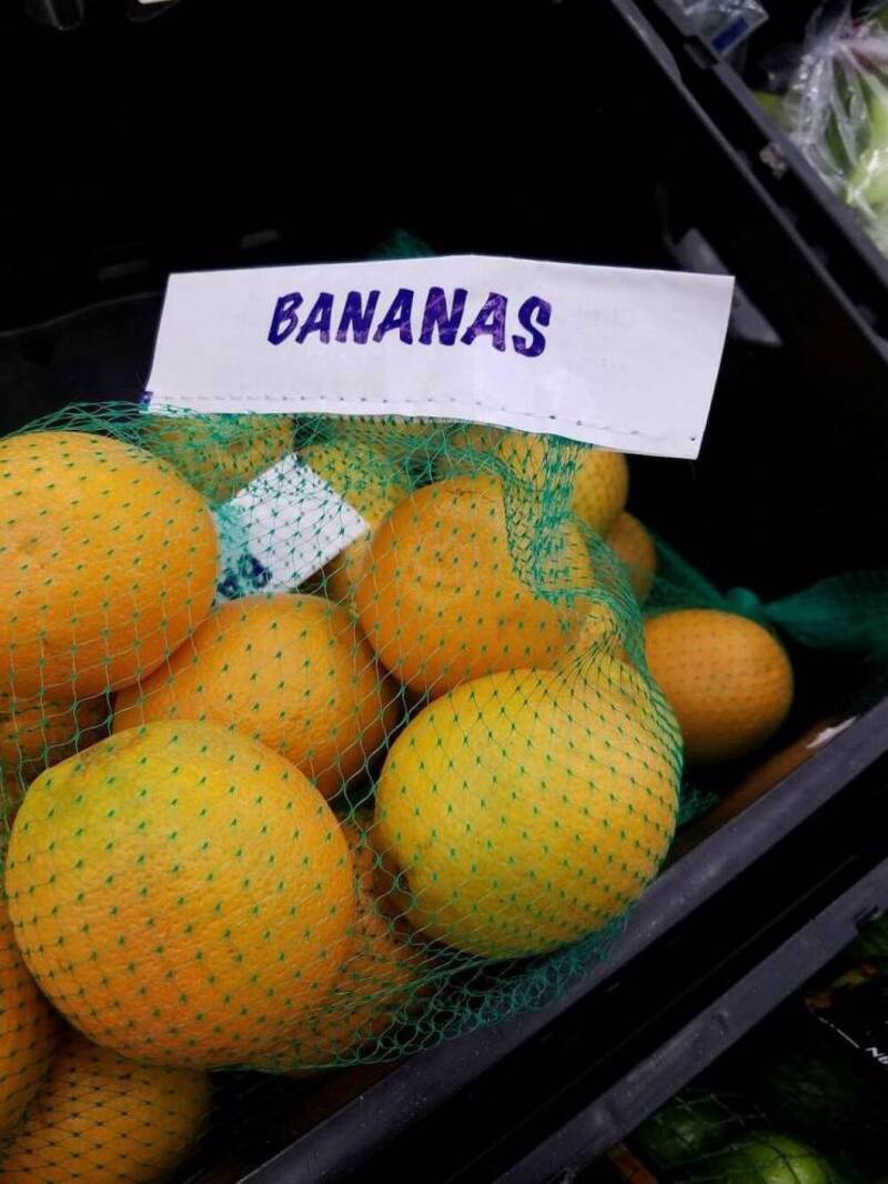 Fresh bananas in a green mesh bag at the grocery store.
