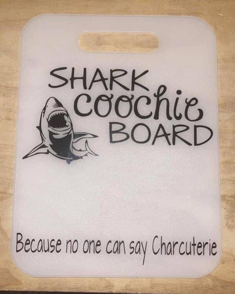 Funny shark-themed charcuterie board with humorous text.