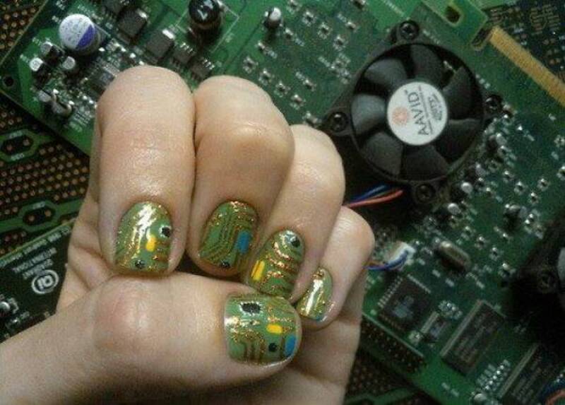 Hand with circuit board nail art on fingers.