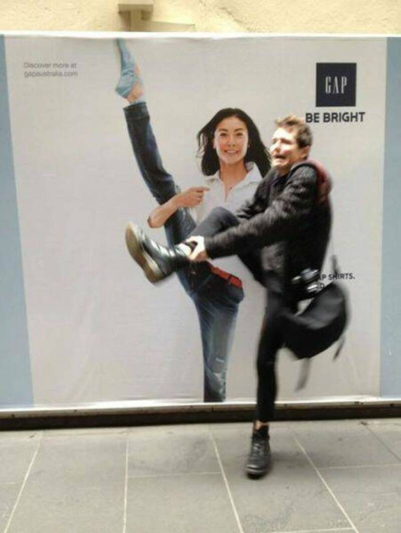 Woman and man jumping in front of a GAP advertisement with "Be Bright" slogan.
