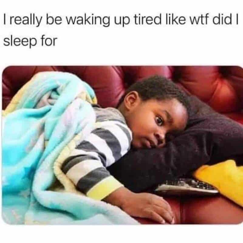 Child lying on couch, looking tired and frustrated after sleep.