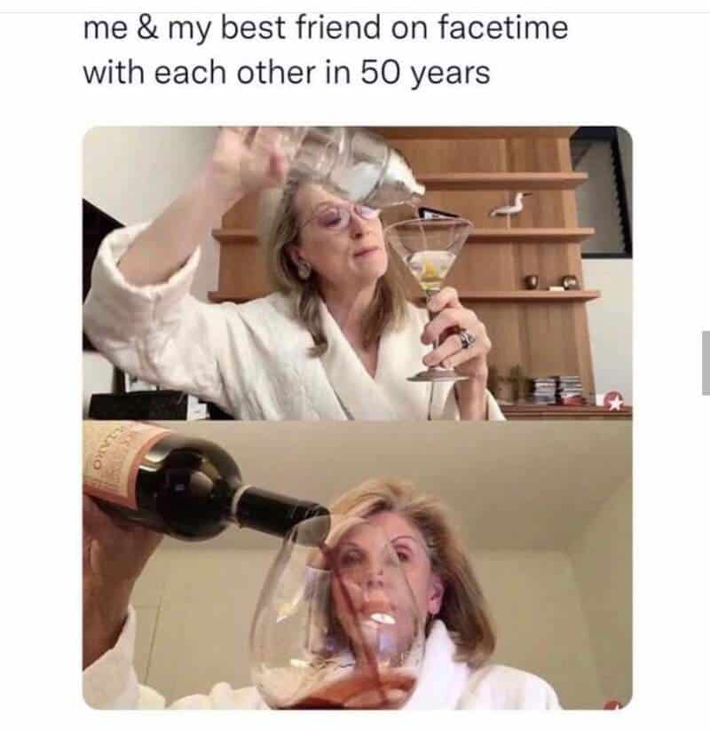 Two women enjoying wine and laughter, celebrating 50 years of friendship.
