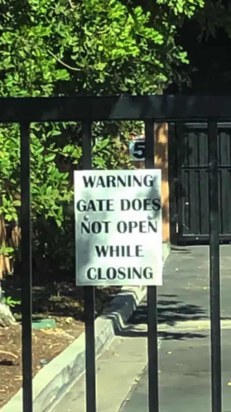 Warning sign on gate indicating it does not open during closing process.