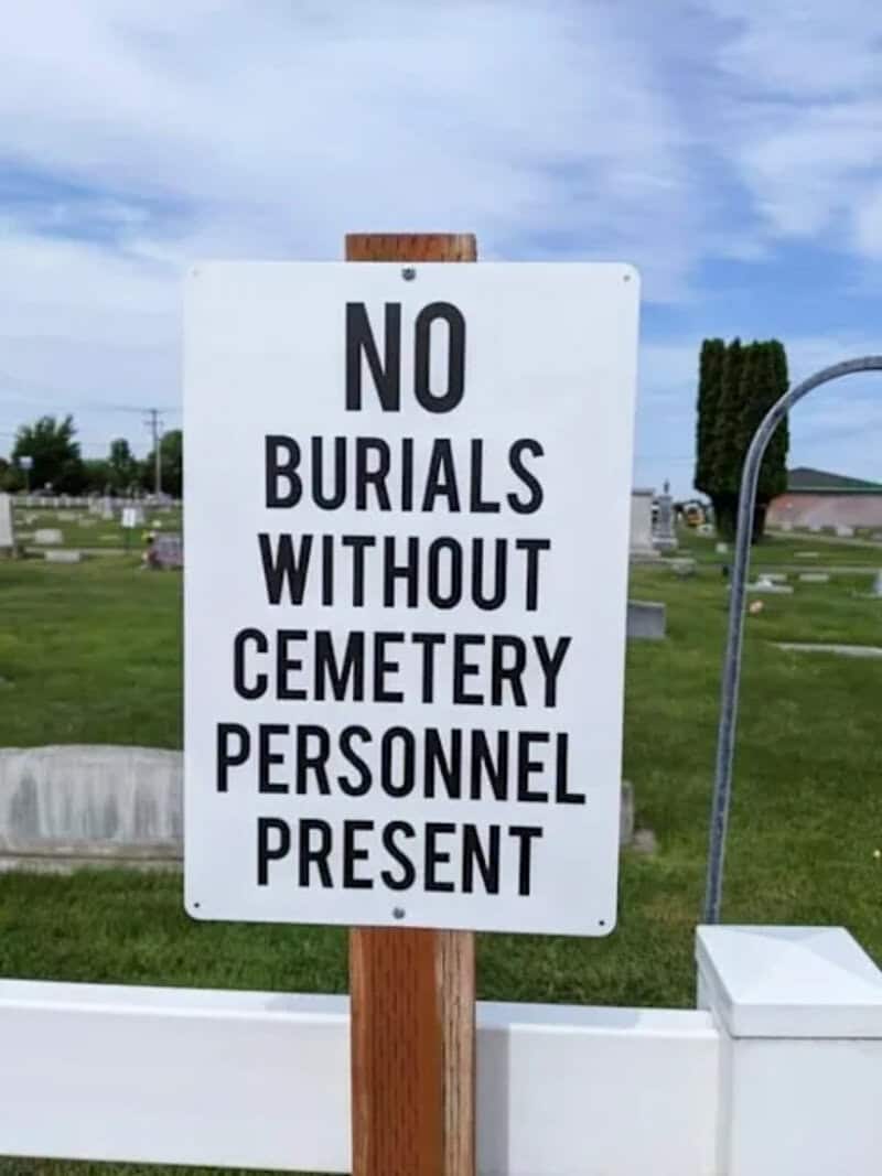Cemetery sign stating no burials allowed without staff present.