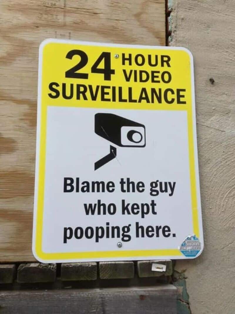 24-hour video surveillance warning sign with humorous message.