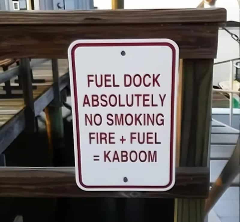 Warning sign at fuel dock prohibiting smoking and open flames for safety.
