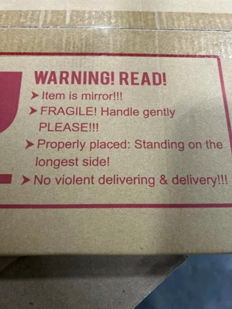 Cardboard box with warning message about fragile mirror item and delivery instructions.
