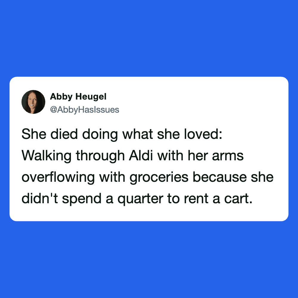 Woman walking with overflowing grocery bags at Aldi store.