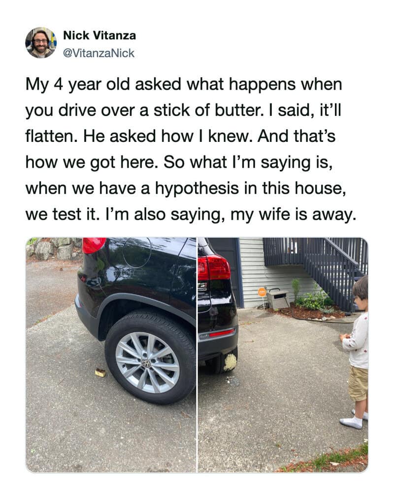 Car parked in driveway with a young boy standing nearby.