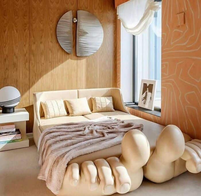 Modern bedroom with unique hand-shaped bed and wooden wall decor.