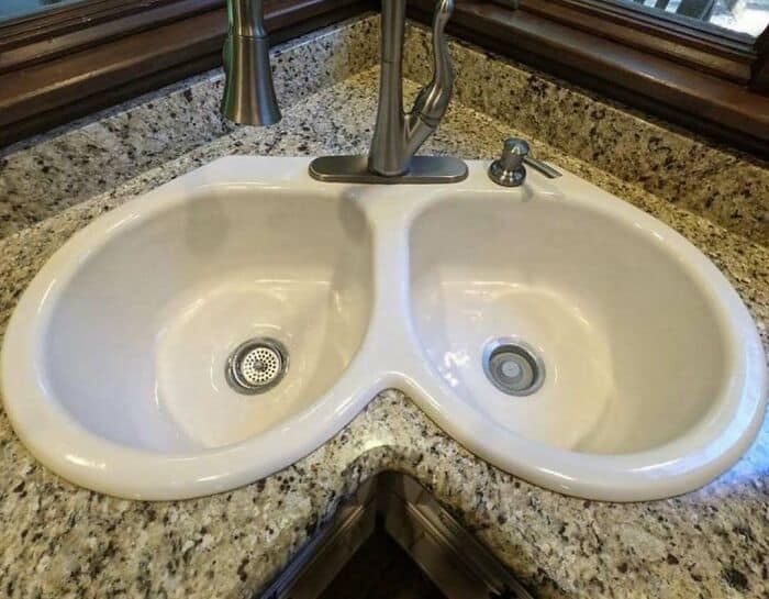 Double sink with granite countertop and chrome faucet.