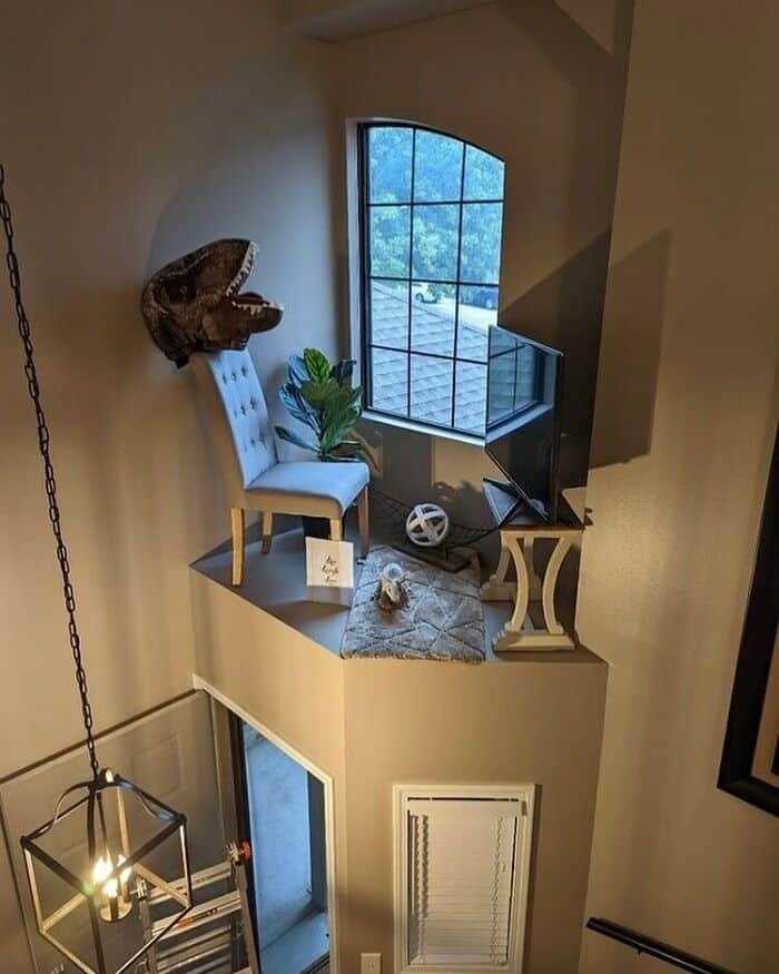 Cozy reading nook with a chair, plant, and window view.
