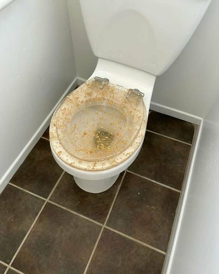 Dirty toilet with stains and grime on the seat and bowl.