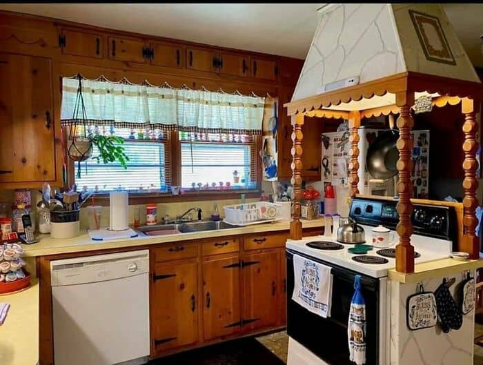 Cozy kitchen with wooden cabinets, white stove, and decorative range hood.