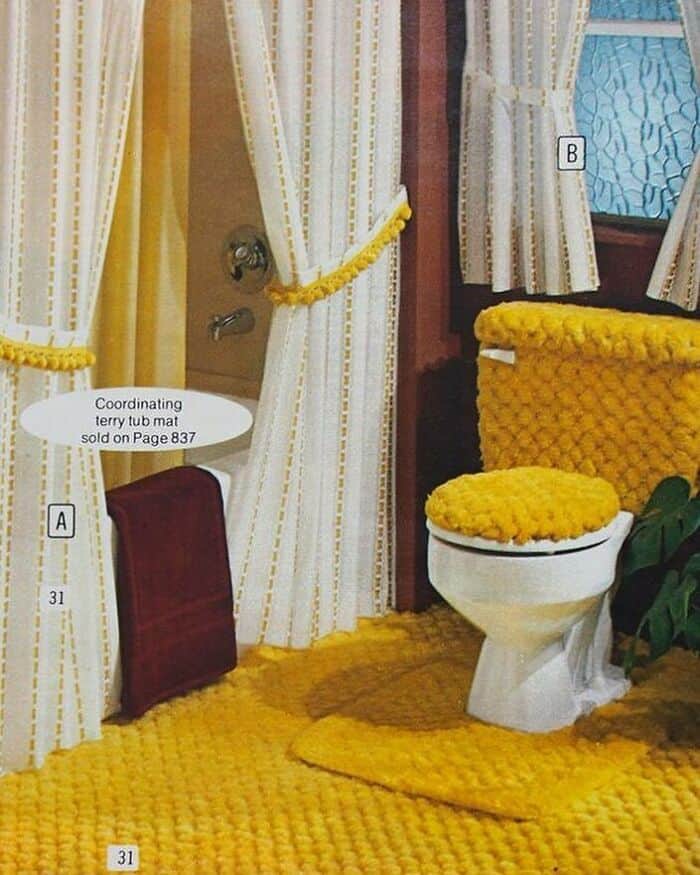 Cozy yellow bathroom with textured accessories and white curtains.