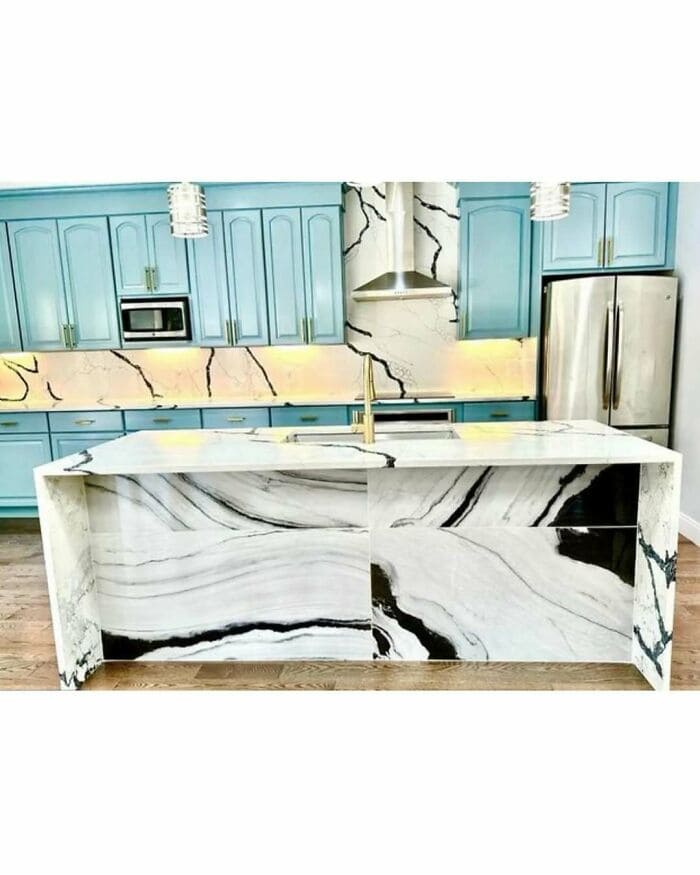 Modern kitchen with blue cabinets and a marble island.