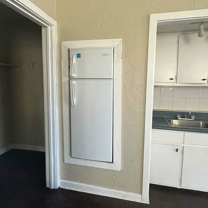 Built-in white refrigerator in a small kitchen nook.
