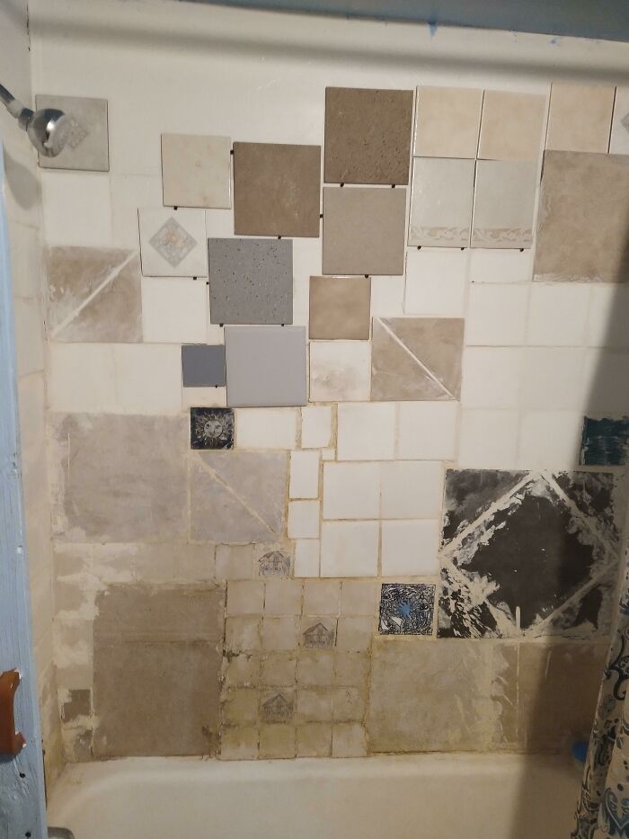 Improperly installed tiles on a bathroom wall with uneven and mismatched placement.