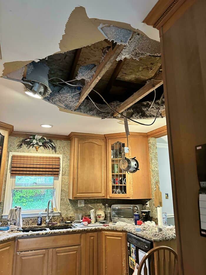 Ceiling with large hole and exposed beams after a renovation mistake.