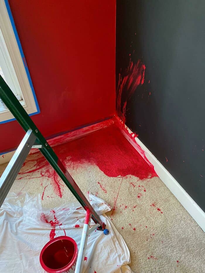 Paint spill on the corner of a room with red and black walls.