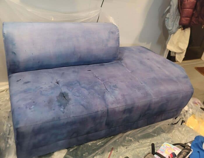 Water-damaged sofa with stains and discoloration from improper cleaning or flooding.