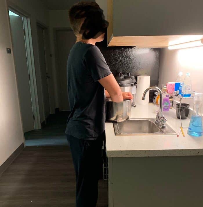 Home improvement fail: person pouring water into rice cooker in kitchen.