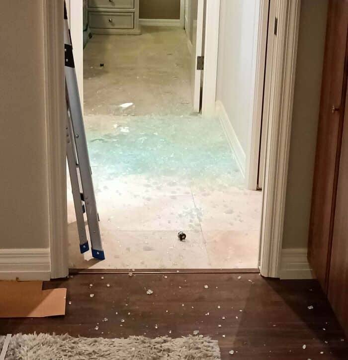 Broken tile floor with spilled grout and debris in doorway.