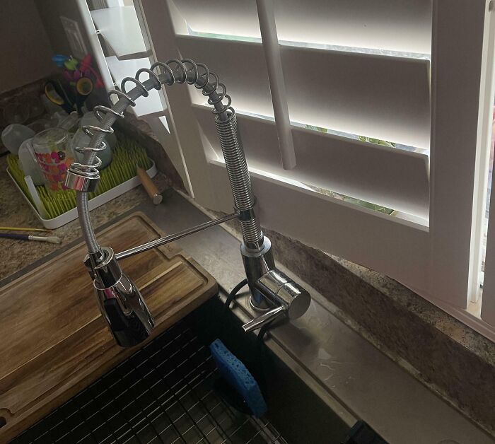 Kitchen sink faucet installed incorrectly with a flexible hose and poor alignment.