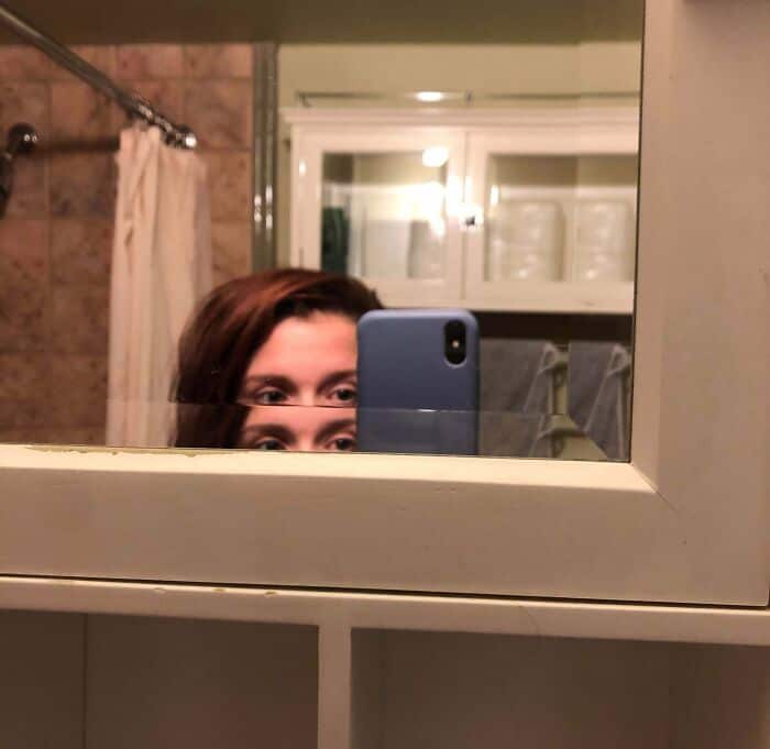 Unaligned bathroom mirror with a gap at the bottom edge.