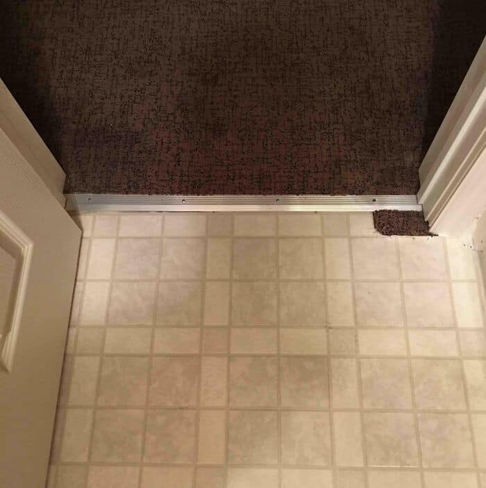Doorway with uneven flooring transition and a makeshift threshold.
