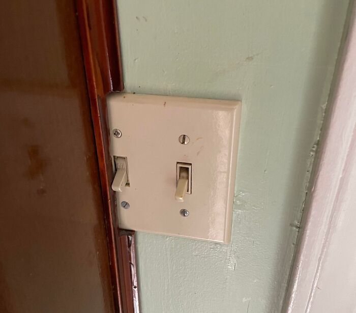 Broken light switch with missing cover plate and exposed wiring.