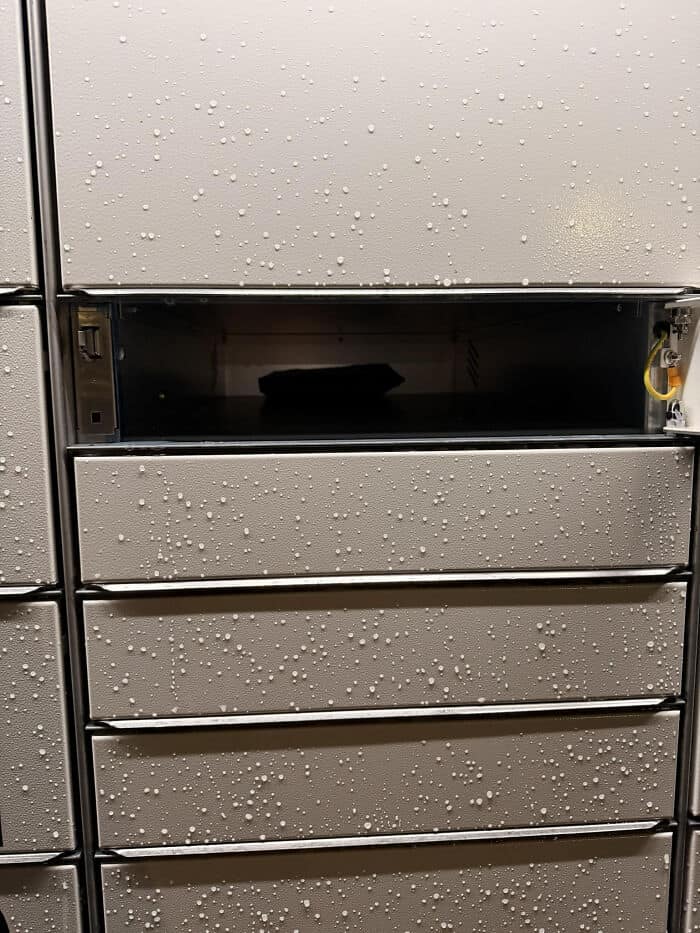 Wet metal lockers with water droplets, showing condensation and moisture on the surface.