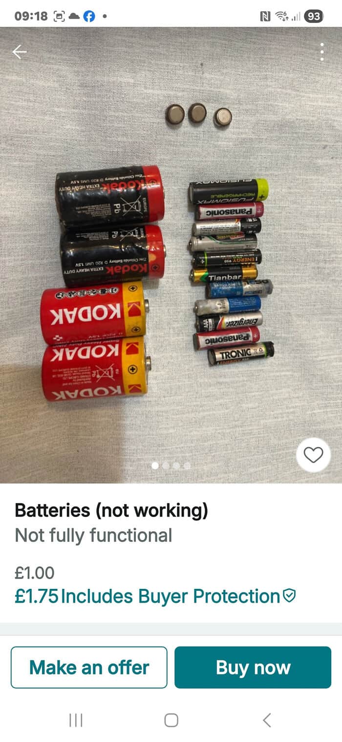 Assorted used batteries, including AA, AAA, and 9V, arranged on a gray surface.