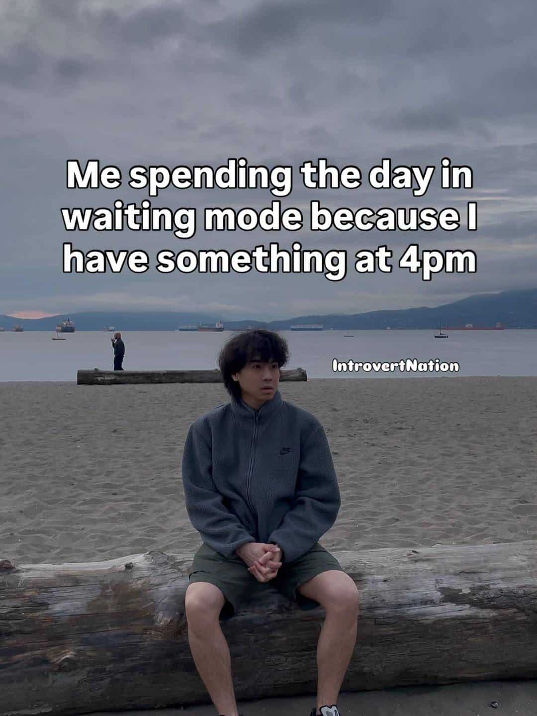 Person sitting on a log at the beach with a cloudy sky background, feeling like waiting mode.