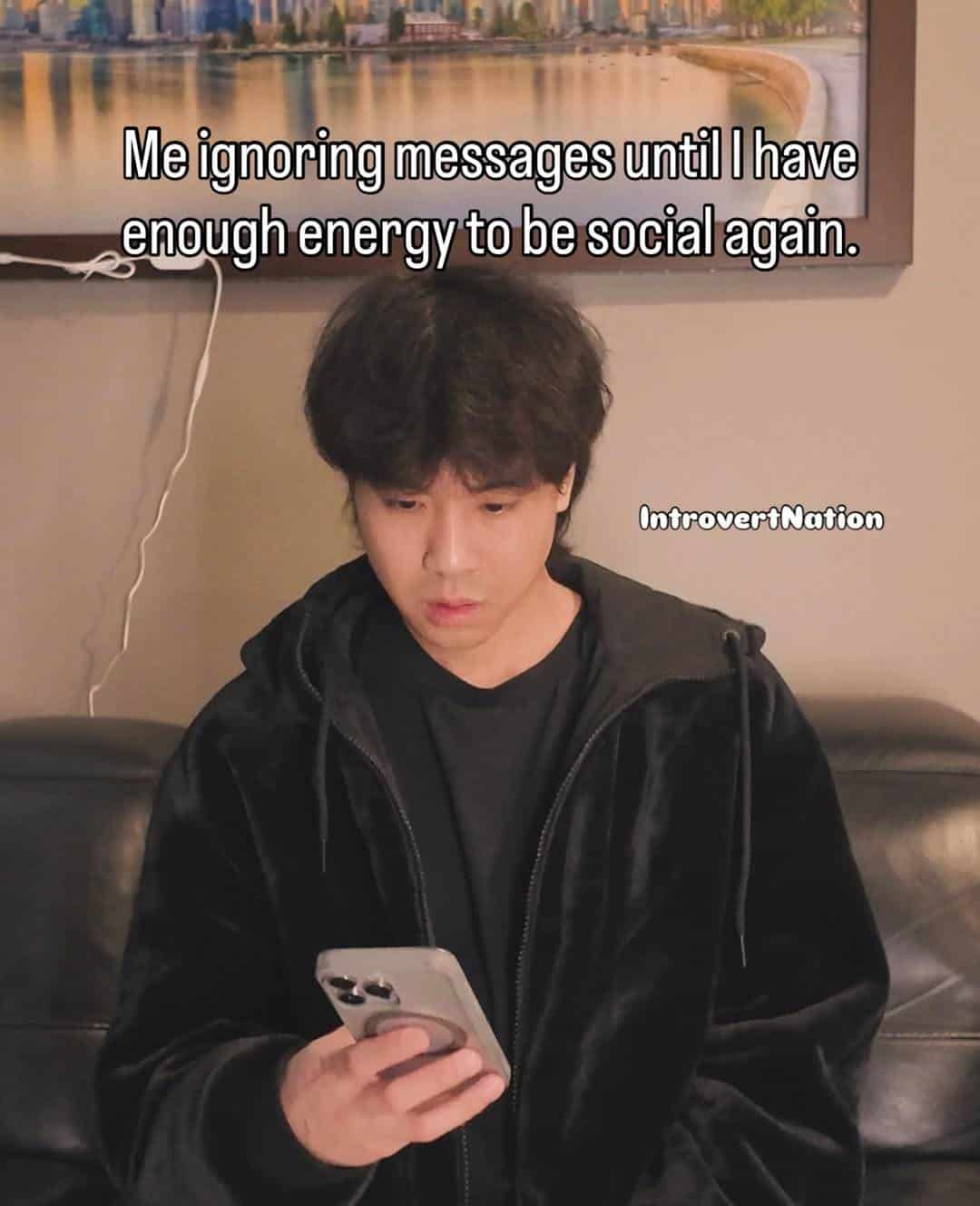 Young man looking at phone with text about ignoring messages until energized.