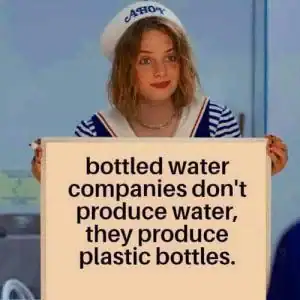 Woman holding a sign about bottled water companies not producing water, only plastic bottles.