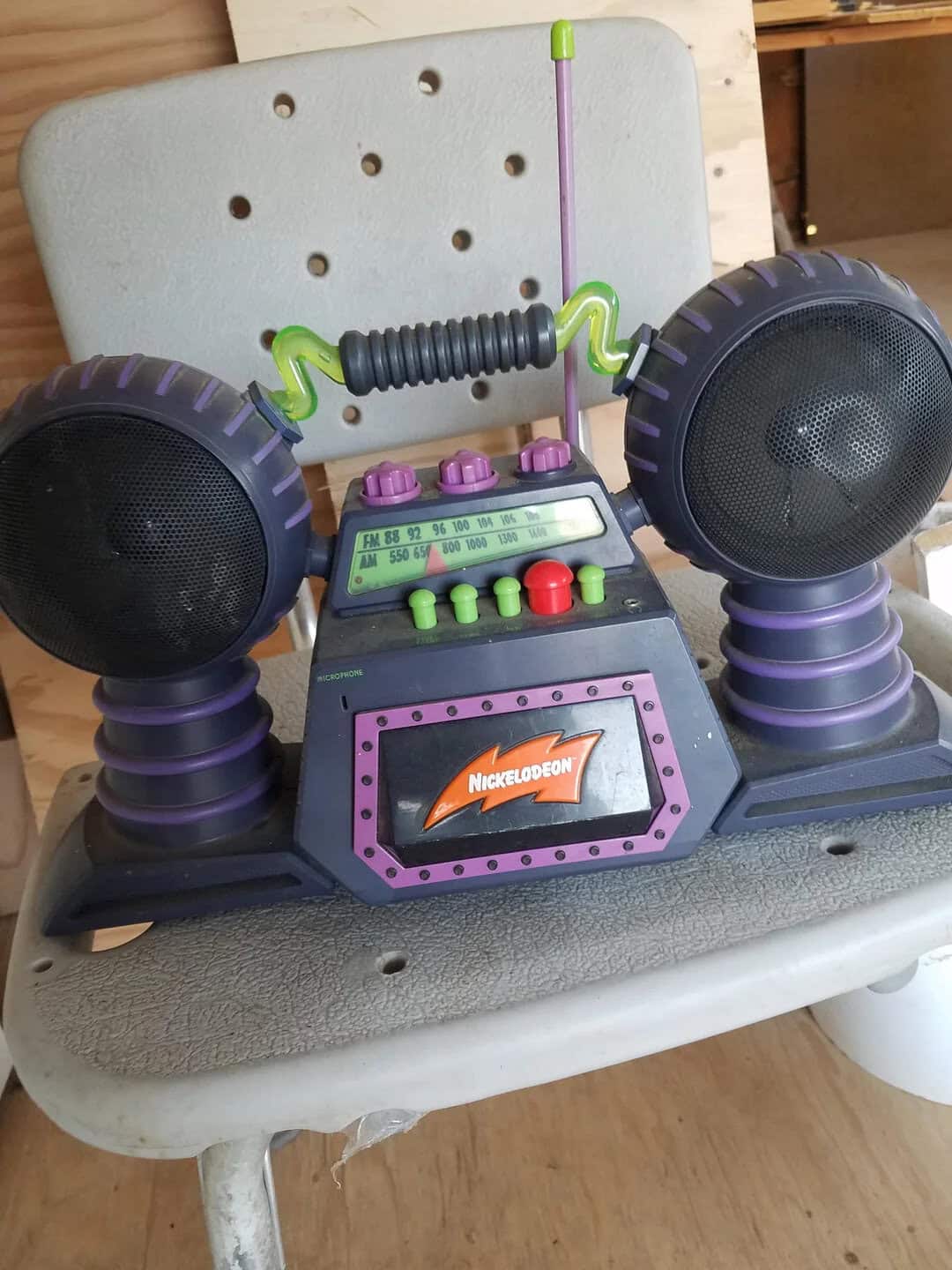 Vintage Nickelodeon-themed toy boombox with dual speakers, colorful buttons, and a handle, perfect f.