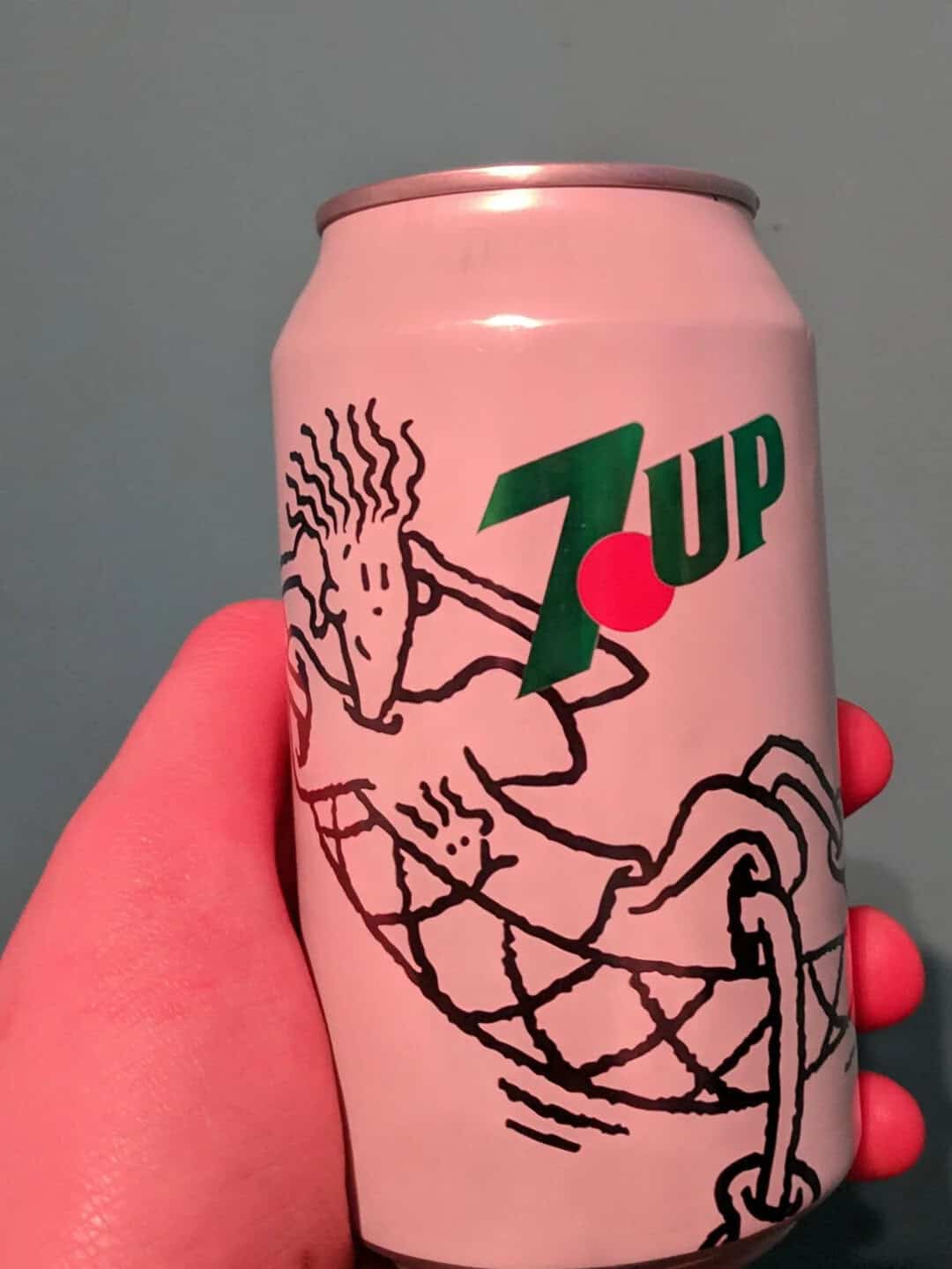 Pink 7UP soda can featuring a cartoon character with spiky hair and a relaxed pose.