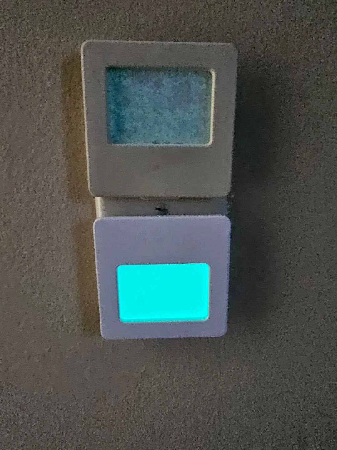 Digital thermostat with illuminated display on wall, showing temperature settings.