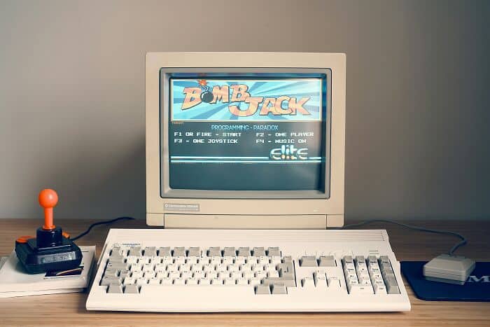 Vintage computer setup displaying Zomback game title on CRT monitor with joystick controller.