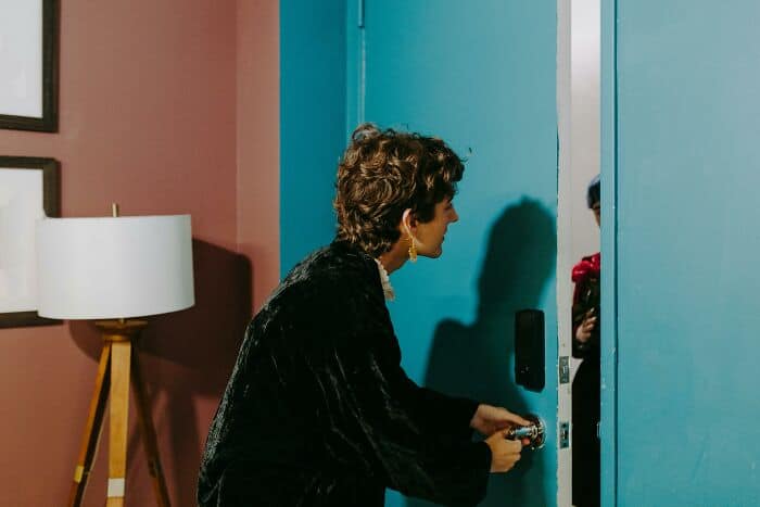 Woman locking a door in a colorful room, casual style, indoor setting.