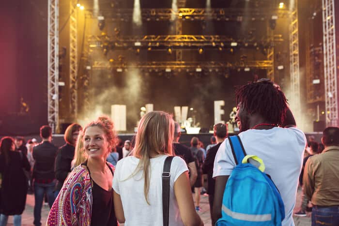 Concert crowd enjoying live music on stage with vibrant lighting.
