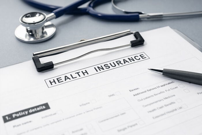 Medical health insurance form with stethoscope and pen on desk.