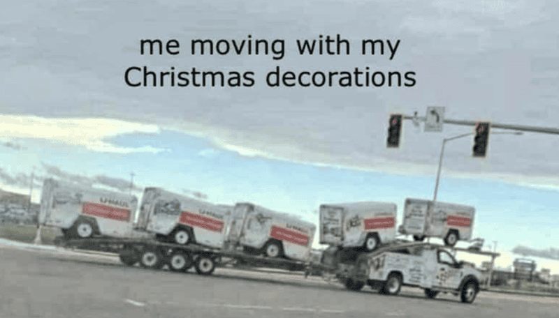 Moving truck decorated with Christmas lights and ornaments, humorous holiday home relocation scene.