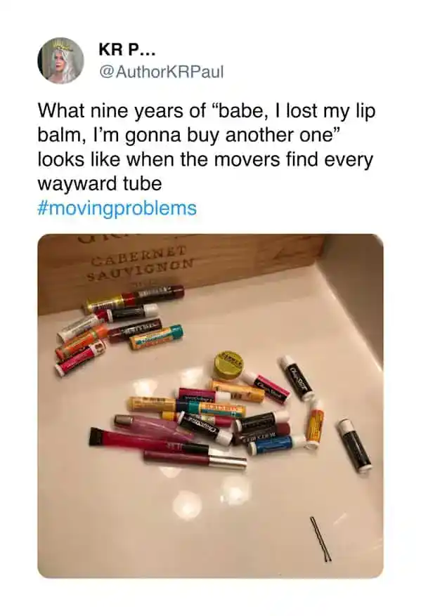 Assorted lip balms scattered on a white surface with a wooden box in the background.